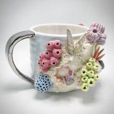 a ceramic mug with sea shells and corals on the inside is sitting on a white surface