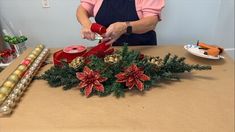 an older woman is making christmas decorations on the table