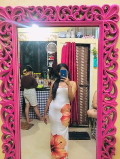 a woman taking a selfie in front of a mirror with pink trimmings