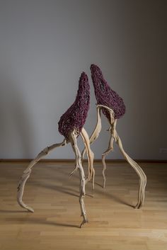 two sculptures made out of driftwood on wooden floors