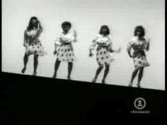 four girls standing in front of a white wall with their hands on their hipss