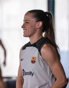 a woman is smiling and wearing a jersey