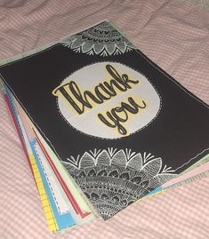 a pile of thank you cards sitting on top of a bed