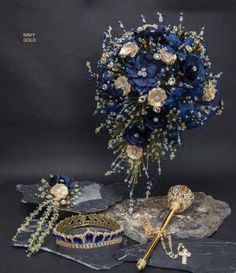 a bouquet of blue flowers and jewelry on a rock with a cross in the middle