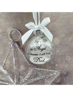 a glass ornament with a star hanging from it's side and the words, they are an angel in heaven i call him dad