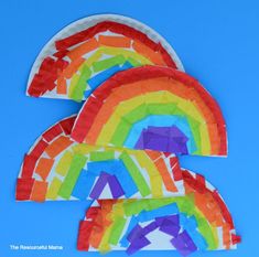 three colorful kites are in the shape of a rainbow on a blue sky background