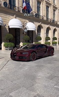 a bugatti is parked in front of a building with french flags on it