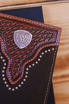 Ariat rodeo wallet by M&F Western Products. This great wallet is made of genuine leather with a basket weave and sunburst embossing and heavy duty stitching. Accented with metal stud trim and an Ariat logo concho in antique silver finish. Slim fit design. Credit card slots and one clear ID pocket for plenty of storage. Western Style Brown Leather Wallet, Western Style Leather Rectangular Wallet, Western Leather Wallets With Card Slots, Western Leather Wallet With Card Slots, Card Slots, Rodeo, Basket Weaving, Antique Silver, Genuine Leather