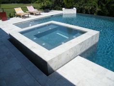 an empty swimming pool surrounded by lounge chairs