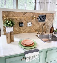 a kitchen counter with plates and cups on it, next to a sink in front of a window