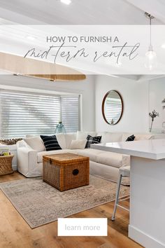 a living room filled with furniture and a kitchen island in front of a white couch