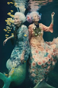 two women dressed as mermaids under water