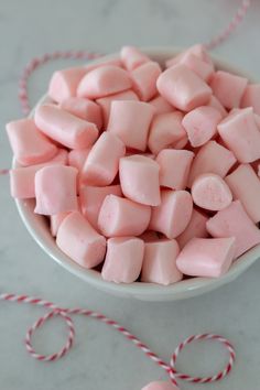 a white bowl filled with pink marshmallows on top of a table