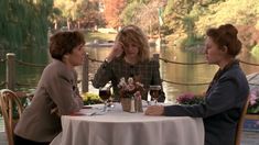 three women sitting at a table talking to each other