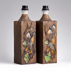 two wooden bottles with designs on them sitting next to each other