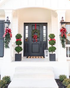 the front door is decorated for christmas with wreaths and bowes on each door