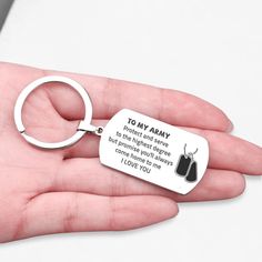 a hand holding a metal key chain with a tag on it that says, to my army protect and serve