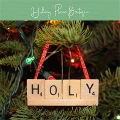 a wooden scrabble hanging from a christmas tree with the word holly spelled on it