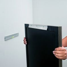 a woman holding up a black piece of furniture