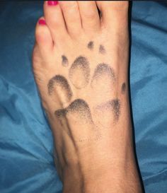 a person with a tattoo on their left foot and paw prints on the right leg