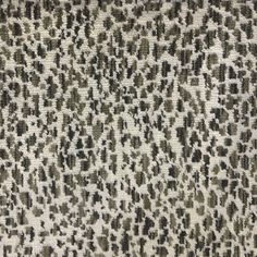 an animal print fabric with black and white spots on the top, in grey tones