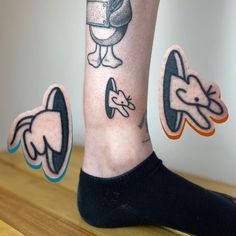 a person's legs with tattoos on them and one has an image of a cartoon character