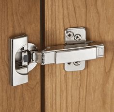 a close up of a door handle on a wooden cabinet with metal latch and hinges