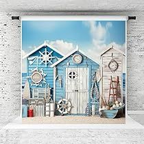 a wall hanging on the side of a white brick building with blue and white beach huts