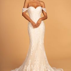 a woman in a white wedding dress with off the shoulder sleeves and an open back