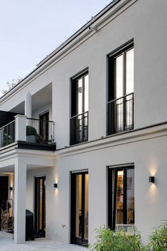 a large white building with black windows and balconies