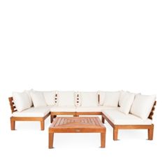 a wooden couch with white pillows and a coffee table in front of it on a white background