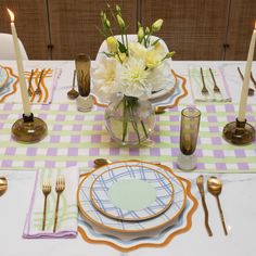 a table set with plates, silverware and flowers