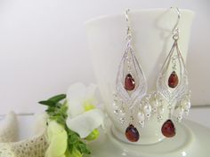 Garnet faceted teardrops are hung on fabulous handcrafted drops of Sterling Silver. Just right for that special holiday dress or even your favorite jeans when you need a little pick me up. These show stoppers will be noticed! Garnet is the official birthstone of January. The deep, glossy red color of garnet so resembles the juicy seeds of a pomegranate, that its name is derived from the Latin word for pomegranate seeds, granatum. In Greek mythology, a pomegranate was often given as a gift of pas Wedding Gemstone Drop Chandelier Earrings, Wedding Chandelier Drop Earrings With Gemstones, Teardrop Gemstone Chandelier Earrings For Wedding, Elegant Teardrop Crystal Earrings With Dangling Beads, Gemstone Teardrop Earrings For Wedding, Gemstone Dangle Chandelier Earrings For Wedding, Wedding Gemstone Teardrop Earrings, Wedding Teardrop Gemstone Earrings, Wedding Chandelier Dangle Earrings With Gemstones