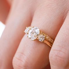 a close up of a person's hand with a gold ring and diamond engagement band