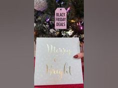 a christmas tree is decorated with pink and gold ornaments, while a black friday sign stands in front of it