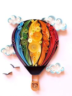 a colorful hot air balloon with swirls and clouds in the background on a white surface