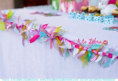 the table is decorated with colorful ribbons and cupcakes