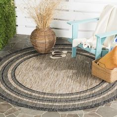 an outdoor rug with a chair and potted plant on the ground next to it