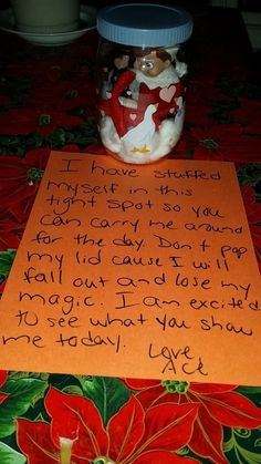 a note written in front of a glass jar filled with candy canes and christmas decorations