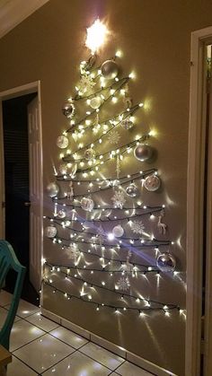 a christmas tree made out of lights in the corner of a room with tiled flooring