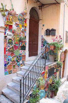 the stairs are decorated with colorful tiles and potted plants in front of the door