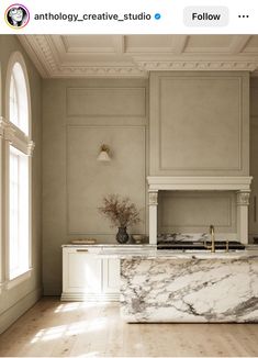 an elegant kitchen with marble counter tops and white cabinetry is featured on instagram