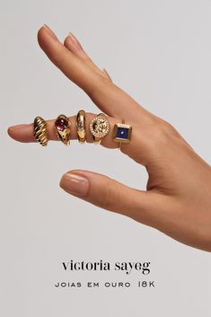 a woman's hand holding five rings with different designs on them and the words victoria saveg written below