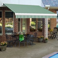 a red and white striped awning next to a swimming pool