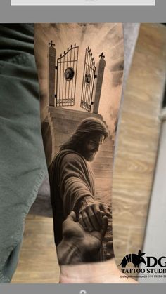 a man's arm with a tattoo on it that has an image of jesus holding the