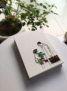 a white table topped with a book and potted plants