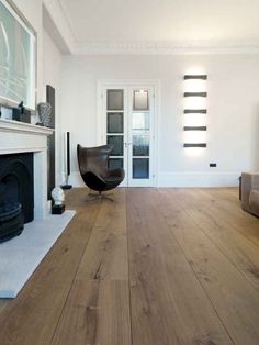 an empty living room with white walls and wood floors