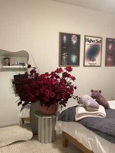 a bedroom with a bed, mirror and flowers on the table in front of it