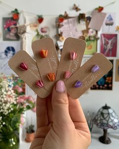 a person holding up some small flowers in their hand with the words love on them