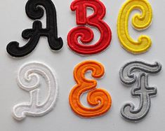 the letters are made up of different colors and sizes, including black, white, yellow, red, and orange